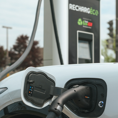 Une voiture électrique se fait charger à une borne de recharge RechargÉco